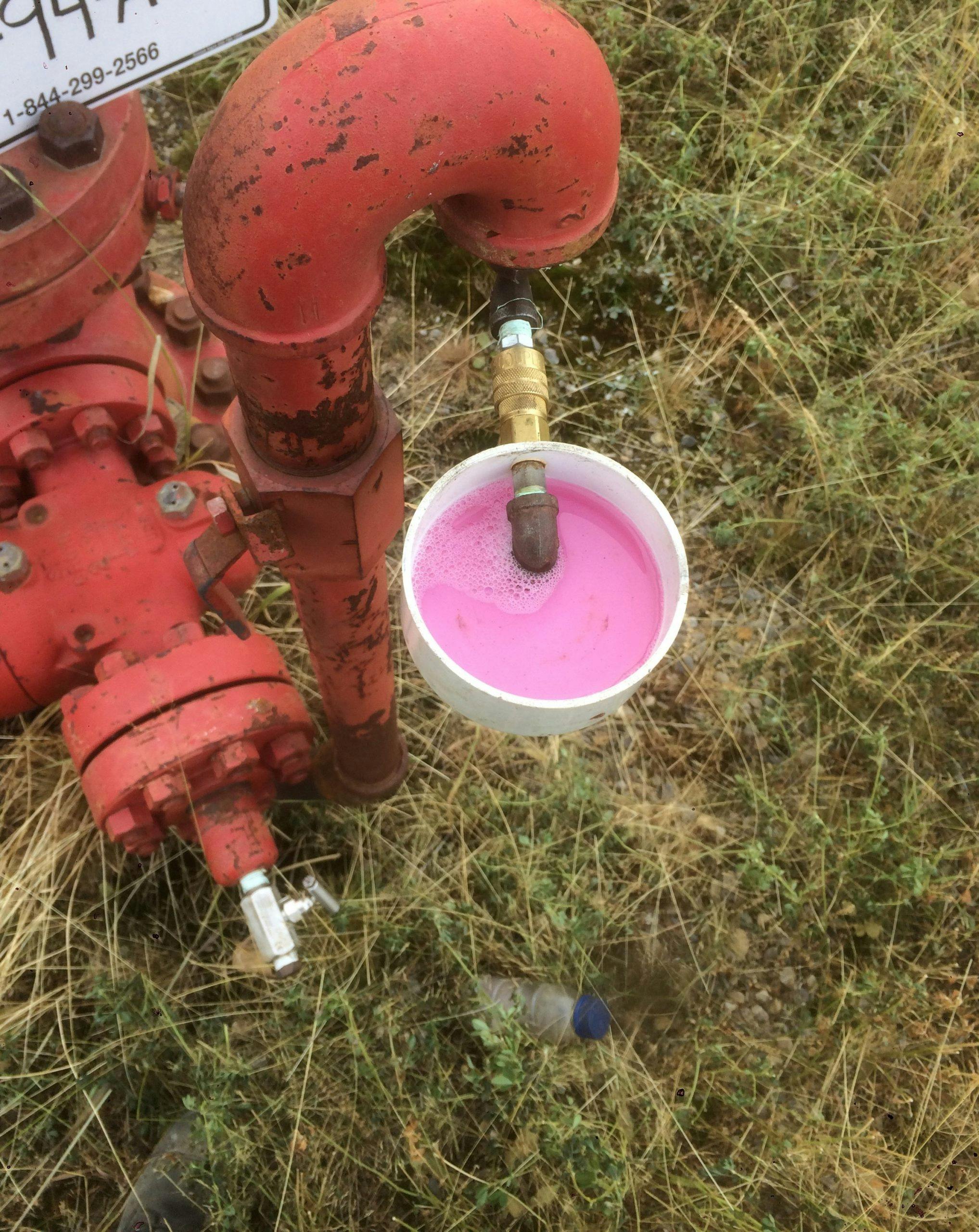 Worker performing a bubble test at a wellhead in Northeast BC