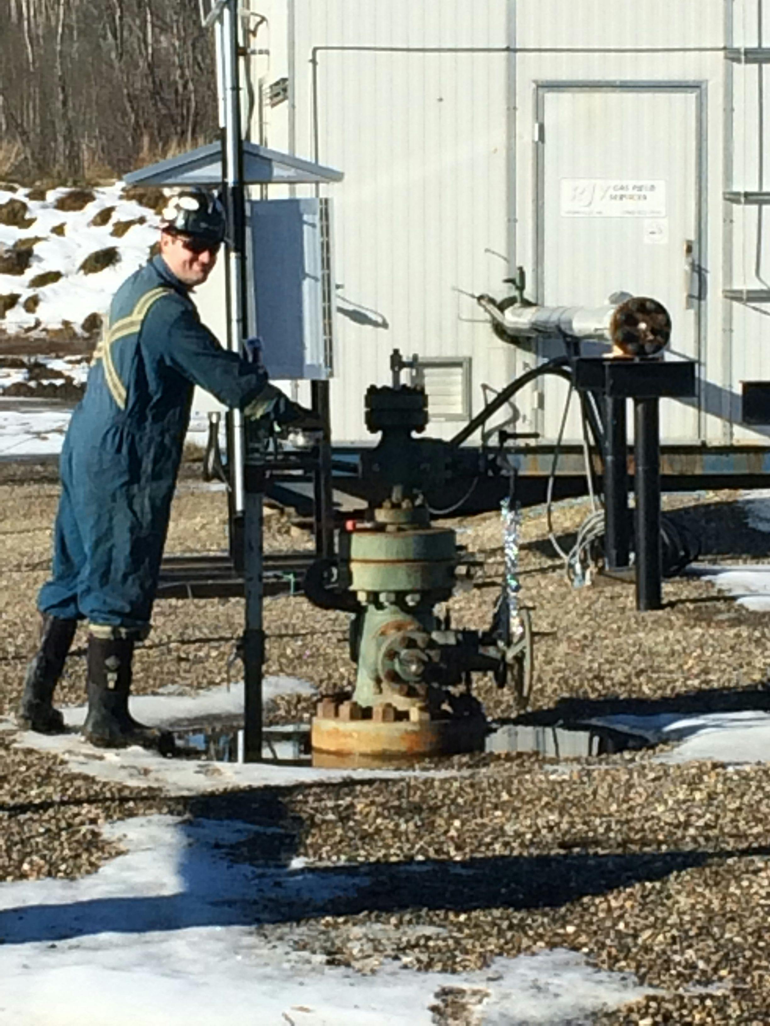 Worker on site in Northeast BC testing a wellhead